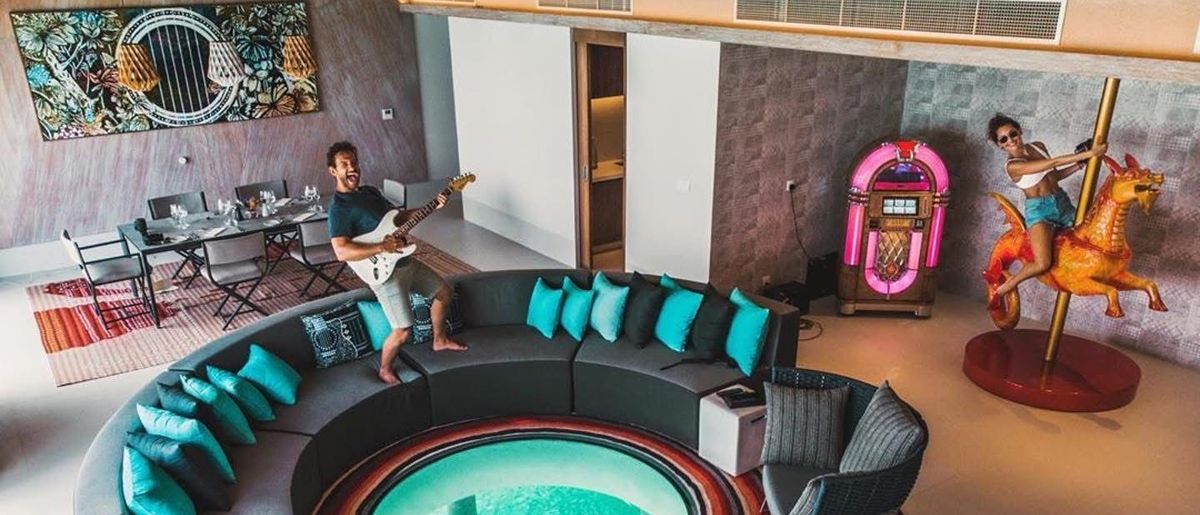 Hotel suite with a sunken lounge and a pink jukebox against the wall