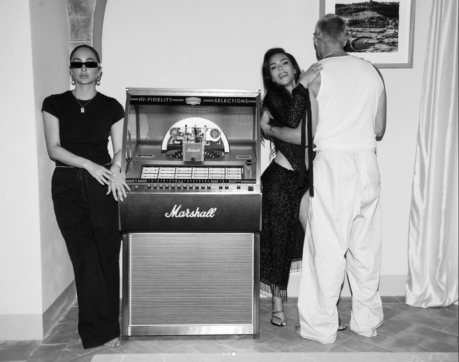 Black-and-white shot of guests around a Marshall jukebox in a stylish interior